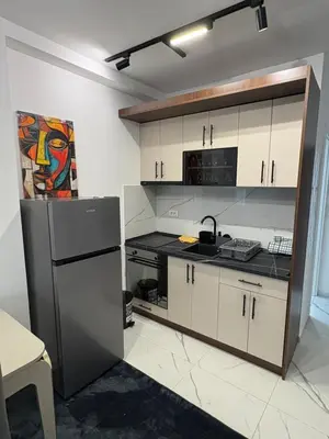 a kitchen with white cabinets and a stainless steel refrigerator at Nik 1 in Kruševac
