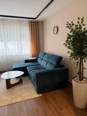 a living room with a blue couch and a table at Zira apartman in Vranje