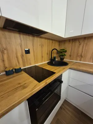 a kitchen with a black sink and a wooden counter at Zira apartman in Vranje