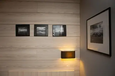 a lamp on a wall with four pictures at Apartment HT in Kopaonik