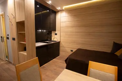a small room with a bed and a kitchen at Apartment HT in Kopaonik