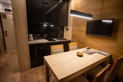 a kitchen and dining room with a wooden table with chairs at Apartment HT in Kopaonik
