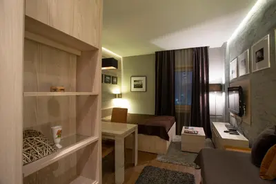 a small room with a bed and a desk in a room at Apartment HT in Kopaonik