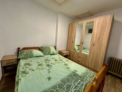 a bedroom with a bed and a wooden cabinet at Urban Apartmens 5 in Jošanička Banja