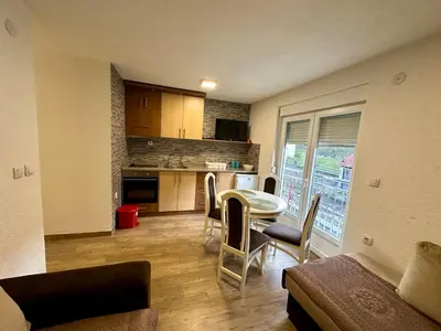 a kitchen and living room with a table and chairs at Urban Apartmens 5 in Jošanička Banja