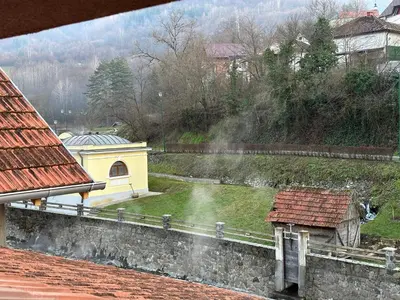 a view of a small yellow building and a yard at Urban Apartmens 5 in Jošanička Banja