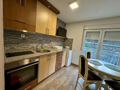 a kitchen with a sink and a table with a dining room at Urban Apartmens 5 in Jošanička Banja