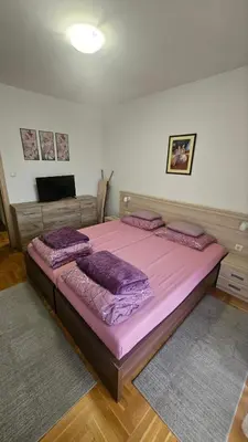 a bedroom with a large pink bed with purple pillows at Vera Solaris in Vrnjci