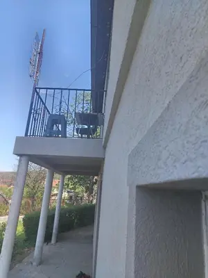 a balcony with a table and chairs on a building at Apartman Poirot in Kuršumlija