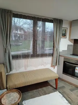 a living room with a window and a couch in front at Apartman 