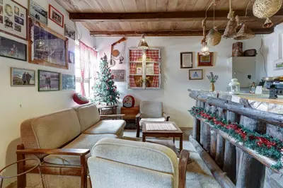 a living room filled with furniture and a christmas tree at Srna Etno Selo - Hotel i Restoran in Inovo