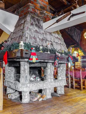 a stone fireplace with a christmas tree on top of it at Srna Etno Selo - Hotel i Restoran in Inovo