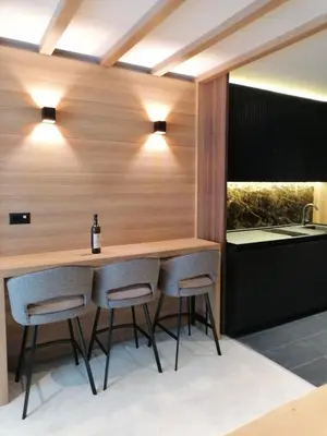 a kitchen with a bar with two stools at Woodside 323 Kopaonik011 in Kopaonik