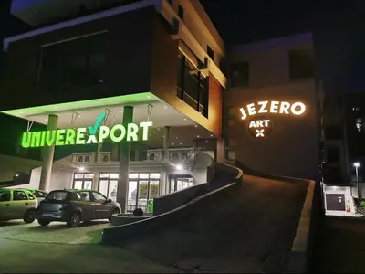a building with a car parked in a parking lot at Lepi Jova JEZERO in Vrnjačka Banja