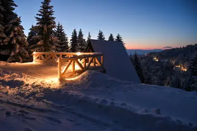 a wooden bench sitting on top of a snow covered slope at Tara mountain house Kopaonik in Kopaonik