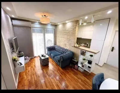 a living room with a blue couch in a room at Niš Central Stay in Niš