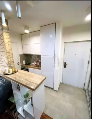 a kitchen with a counter and a white refrigerator at Niš Central Stay in Niš