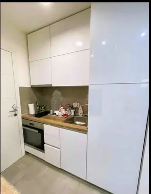 a kitchen with white cabinets and a sink at Niš Central Stay in Niš
