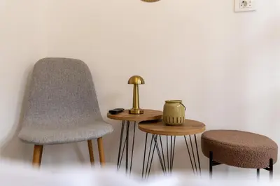 two chairs and a table with a lamp and a stool at Urban Nest Apartments in Niš