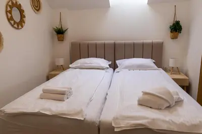 two beds in a bedroom with towels on them at Urban Nest Apartments in Niš