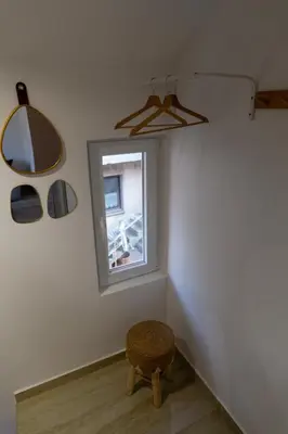 a corner of a room with a window and a stool at Urban Nest Apartments in Niš