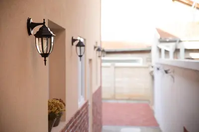two lights on the side of a building with a window at Urban Nest Apartments in Niš