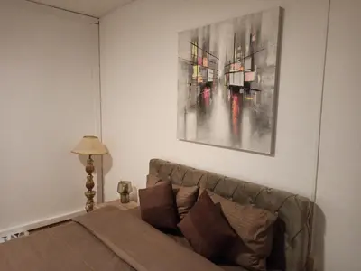 a living room with a couch and a painting on the wall at Bella Notte apartments in Niš