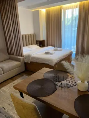 a room with a bed and a table with hats on it at E&E Apartman in Kopaonik