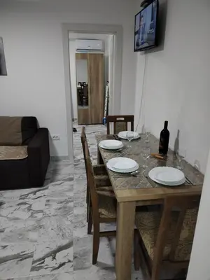 a dining room with a table and a couch at Apartman Ristic Vrnjacka banja in Vrnjačka Banja
