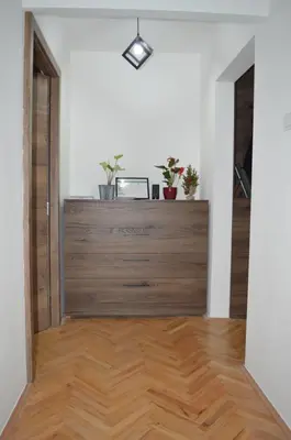 an empty room with a door and a wooden floor at Gohemi Apartments in Pirot