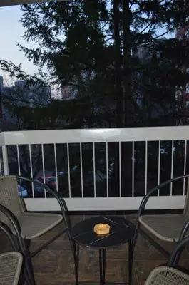 a bench with a table and chairs on a balcony at Gohemi Apartments in Pirot