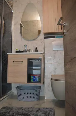 a bathroom with a sink and a toilet and a mirror at Gohemi Apartments in Pirot