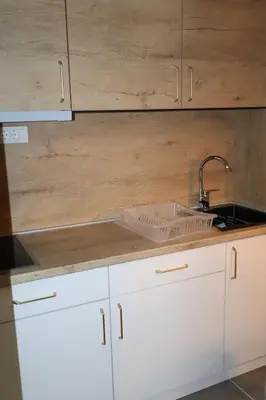 a kitchen with white cabinets and a sink and a counter at Apartmani Vidik,Treska in Kopaonik