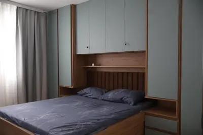 a bedroom with a bed and white cabinets at Apartmani Vidik,Treska in Kopaonik
