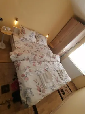 a small bedroom with a bed with flowers on it at Mala Sirena in Bukorovac