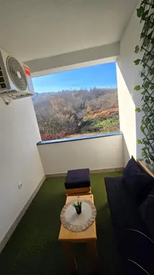 a room with a table and a large window at Panoramic Nest in Vrnjačka Banja