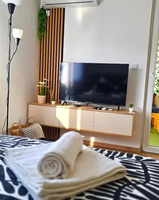 a bedroom with a large flat screen tv on a bed at Panoramic Nest in Vrnjačka Banja