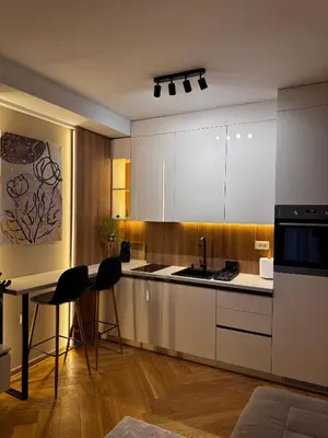 a kitchen with white cabinets and a table and chairs at Studio Georgijev in Vrnjačka Banja