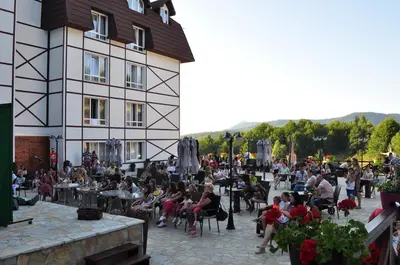 a crowd of people sitting outside of a building at Apartmani Kraljevi Čardaci in Kopaonik