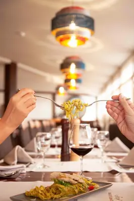 two people eating at a table with a plate of food at Apartmani Kraljevi Čardaci in Kopaonik