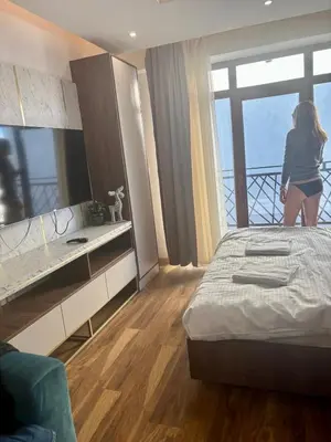 a woman is standing in a bedroom with a bed at Mountain View President Kop in Kopaonik