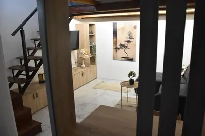 a living room with a staircase and a table at Fiko Apartment in Niš