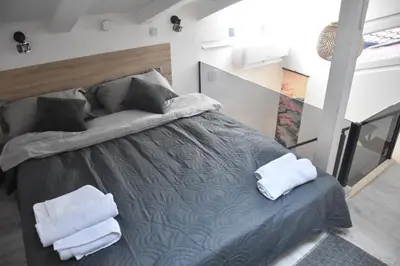a bedroom with a bed with two towels on it at Fiko Apartment in Niš