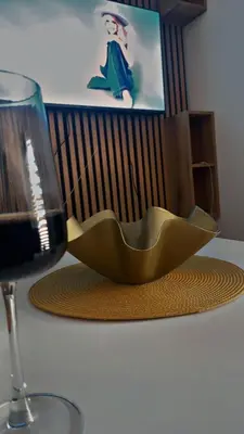 a table with a glass of wine and a bowl on it at Apartman Đorđevic in Vrnjačka Banja