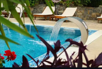 a pool with a water fountain next to some chairs at Apartman Đorđevic in Vrnjačka Banja