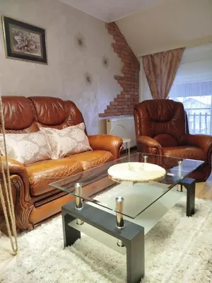 a living room with leather couches and a coffee table at Relax URBAN Life in Zaječar