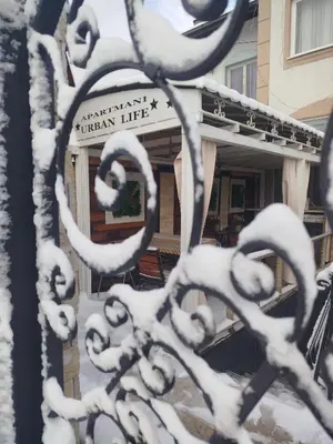 a snow covered building with a sign in front of it at Relax URBAN Life in Zaječar
