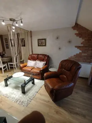 a living room with two leather chairs and a table at Relax URBAN Life in Zaječar