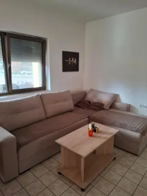 a living room with a brown couch and a coffee table at Nature Nest Više Selo in Blace