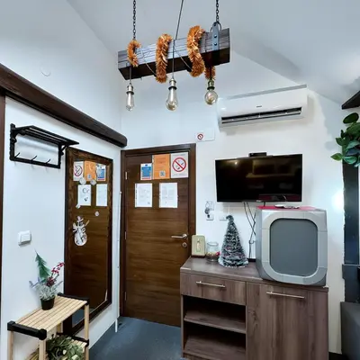 a living room with a tv and a door at Hedonia Luxury Rooms in Pirot